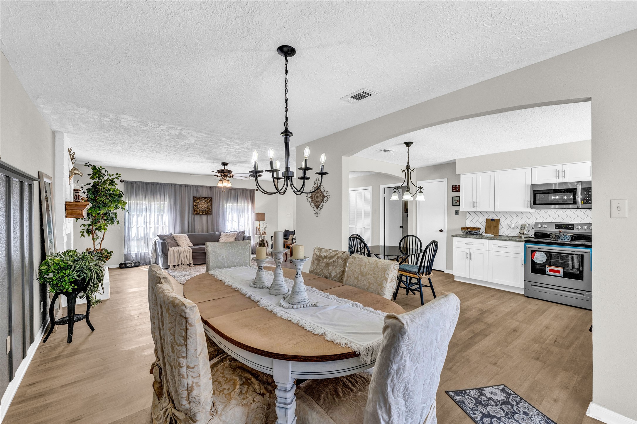 2705 Parrott Avenue Rosenberg, TX 77471 - Photo 10 of 27 a view of a dining room and livingroom with furniture wooden floor a chandelier