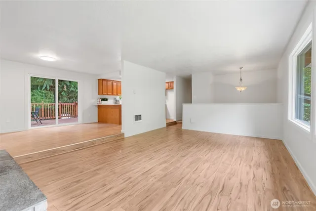 a view of empty room with wooden floor and window