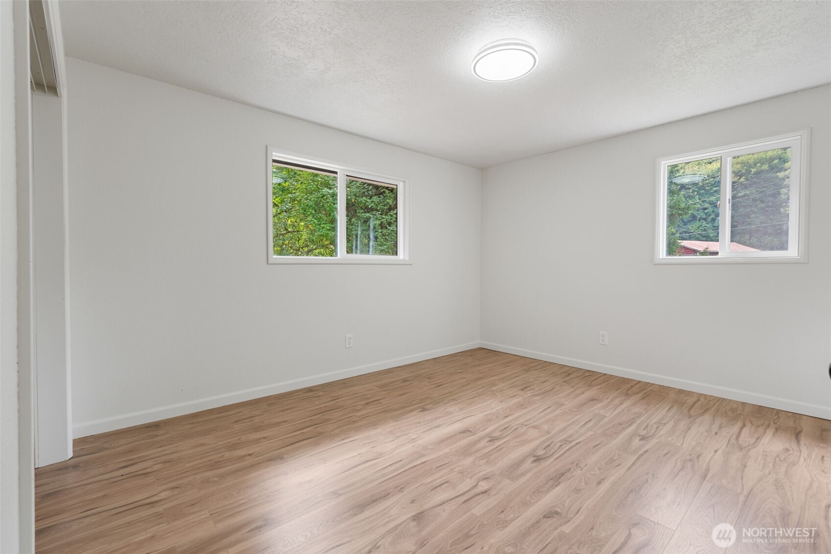115 Maschke Road Vader, WA 98593 - Photo 19 of 40 an empty room with wooden floor and windows