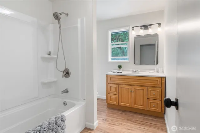 a bathroom with a tub sink and mirror