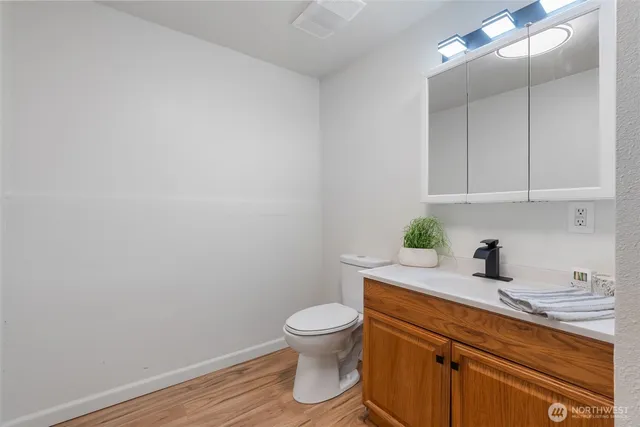 a bathroom with a granite countertop toilet and a sink