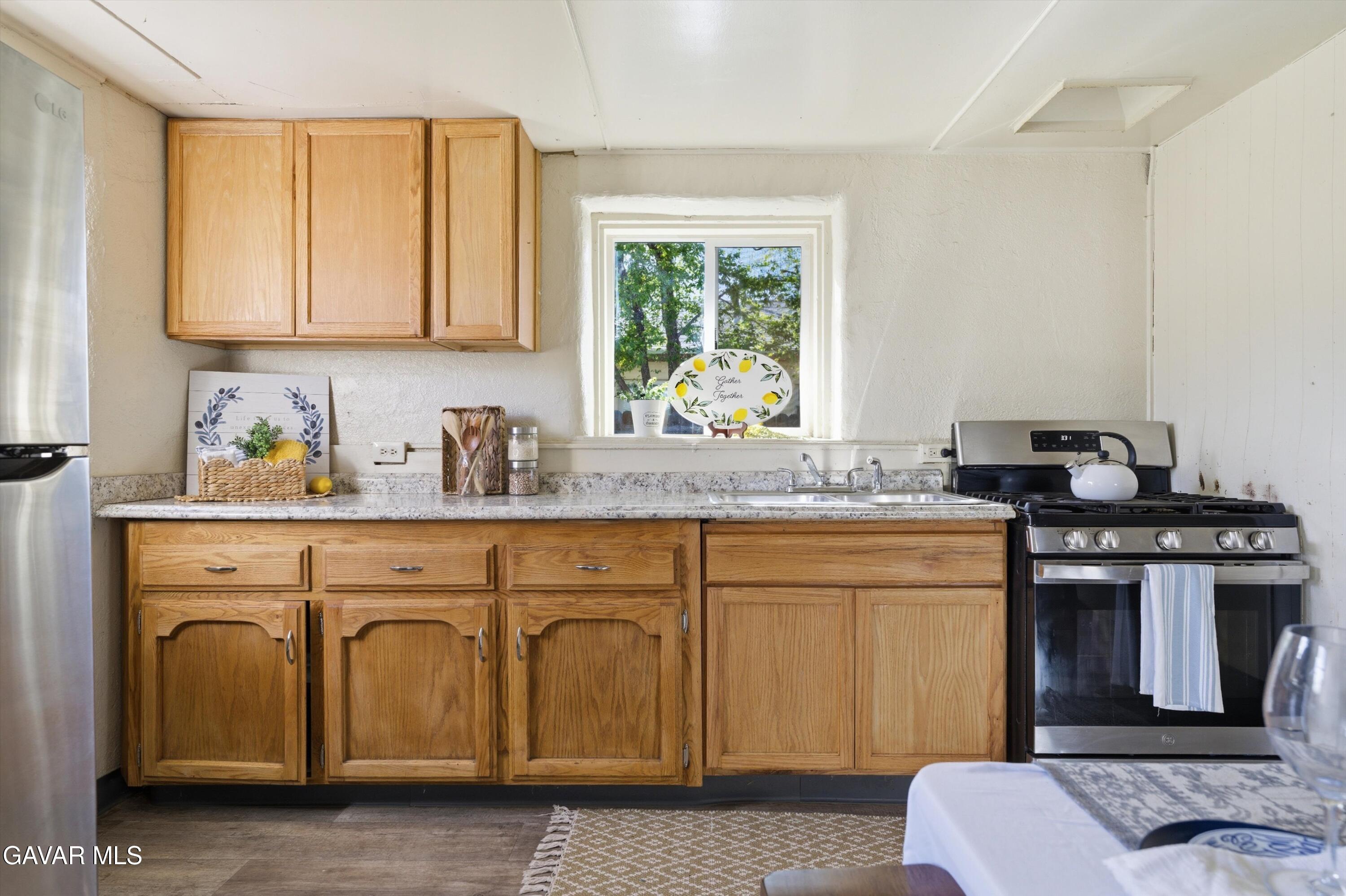 124 I Street East Tehachapi, CA 93561 - Photo 6 of 15 a kitchen with stainless steel appliances granite countertop a sink stove and cabinets
