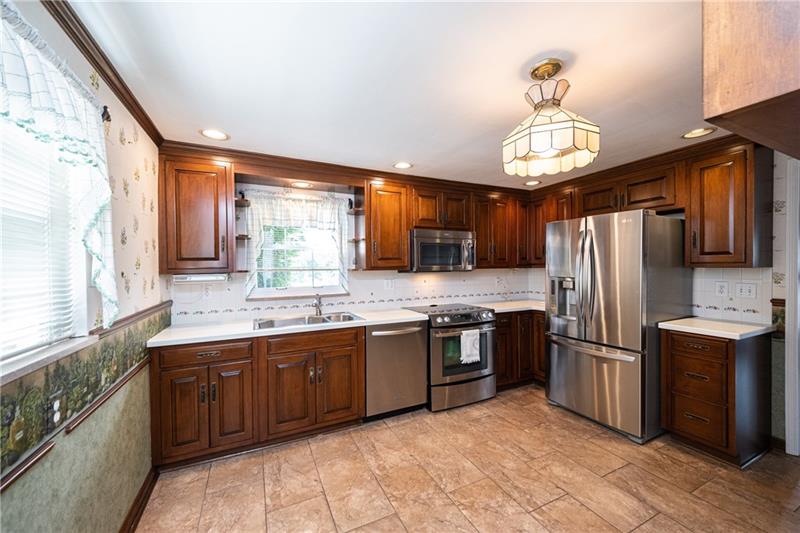 340 Orchard Spring Road Pittsburgh, PA 15220 - Photo 4 of 25 Large eat-in kitchen is appointed with stainless steel appliances, dark cabinets, recessed lighting & ceramic tile flooring.
