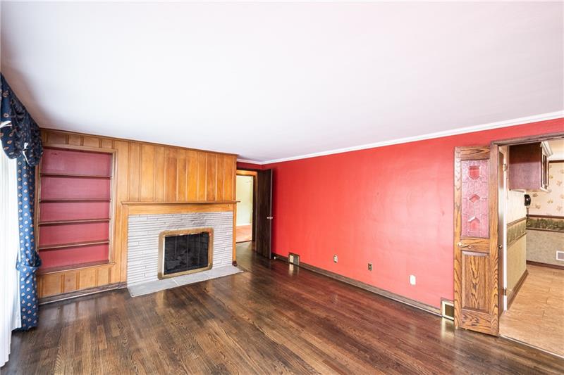340 Orchard Spring Road Pittsburgh, PA 15220 - Photo 5 of 25 Appreciate the living room's original dark stained hardwood floor, built in shelves for your library of reading materials and the warmth of the gas/log optional fireplace.