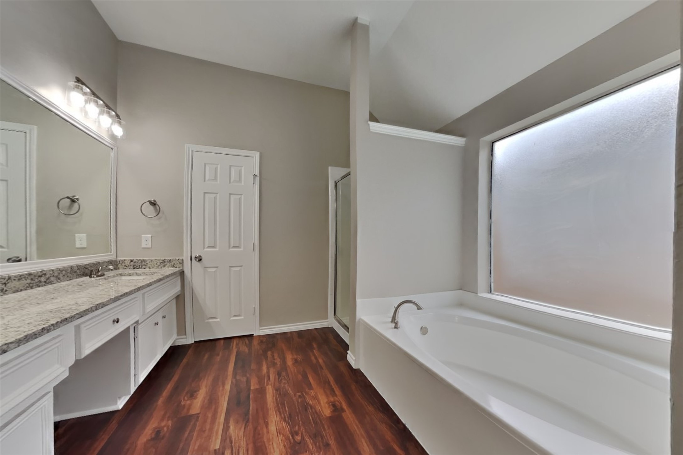 12711 Cedar Grove Court Humble, TX 77346 - Photo 11 of 20 a bathroom with a granite countertop sink a large mirror and a bathtub
