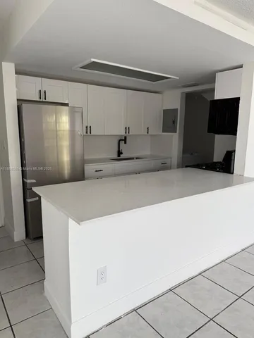 a view of a kitchen with refrigerator and microwave