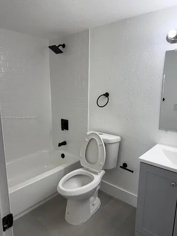 a white toilet sitting next to a bath tub