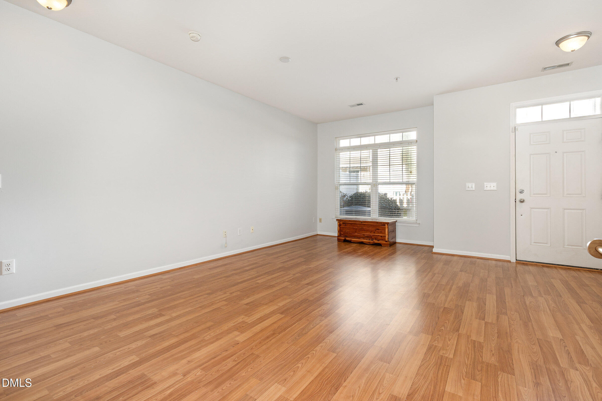 8620 Neuse Club Lane Raleigh, NC 27616 - Photo 4 of 26 an empty room with wooden floor and floor to ceiling window