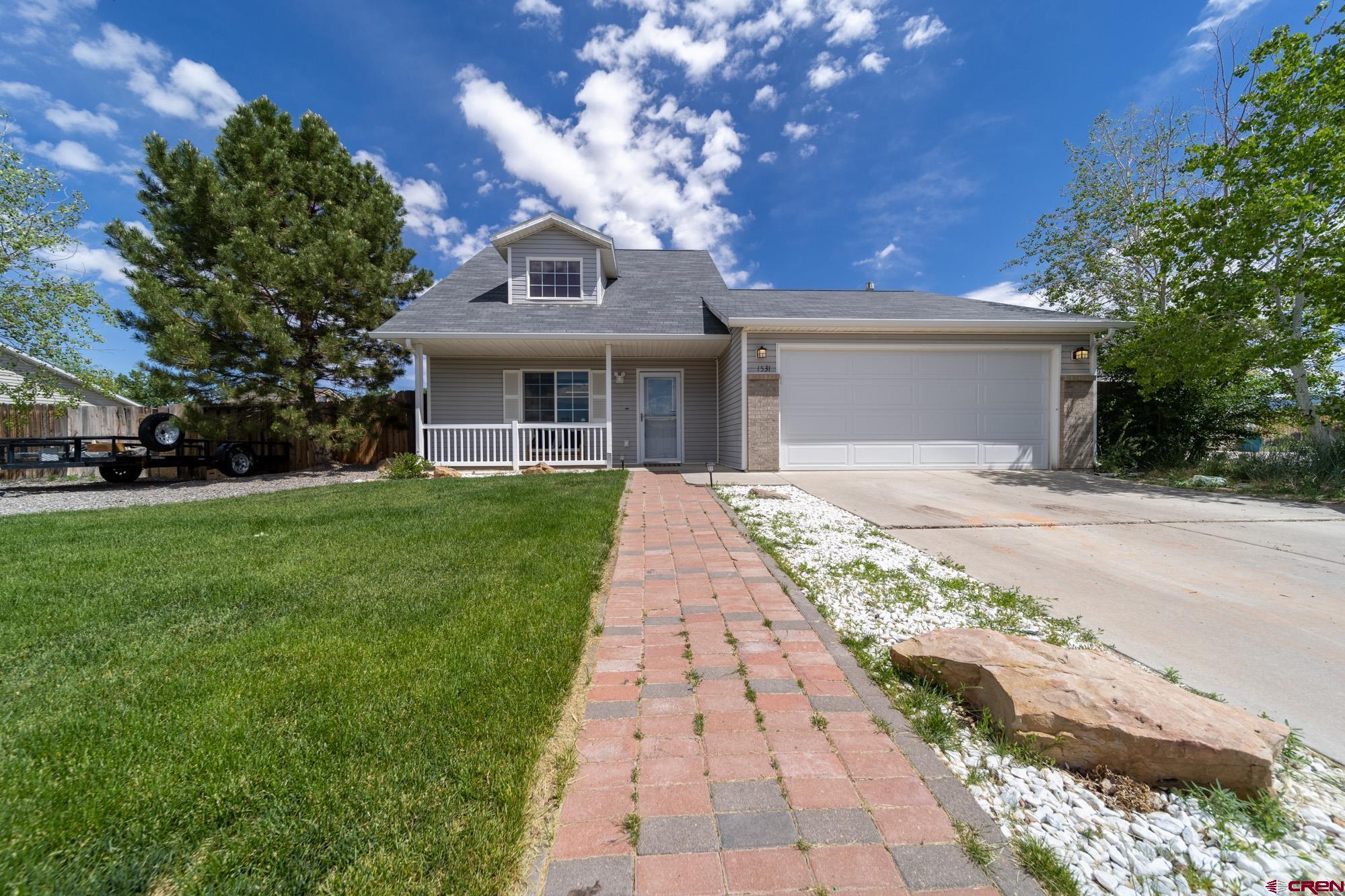 a front view of a house with a garden and trees