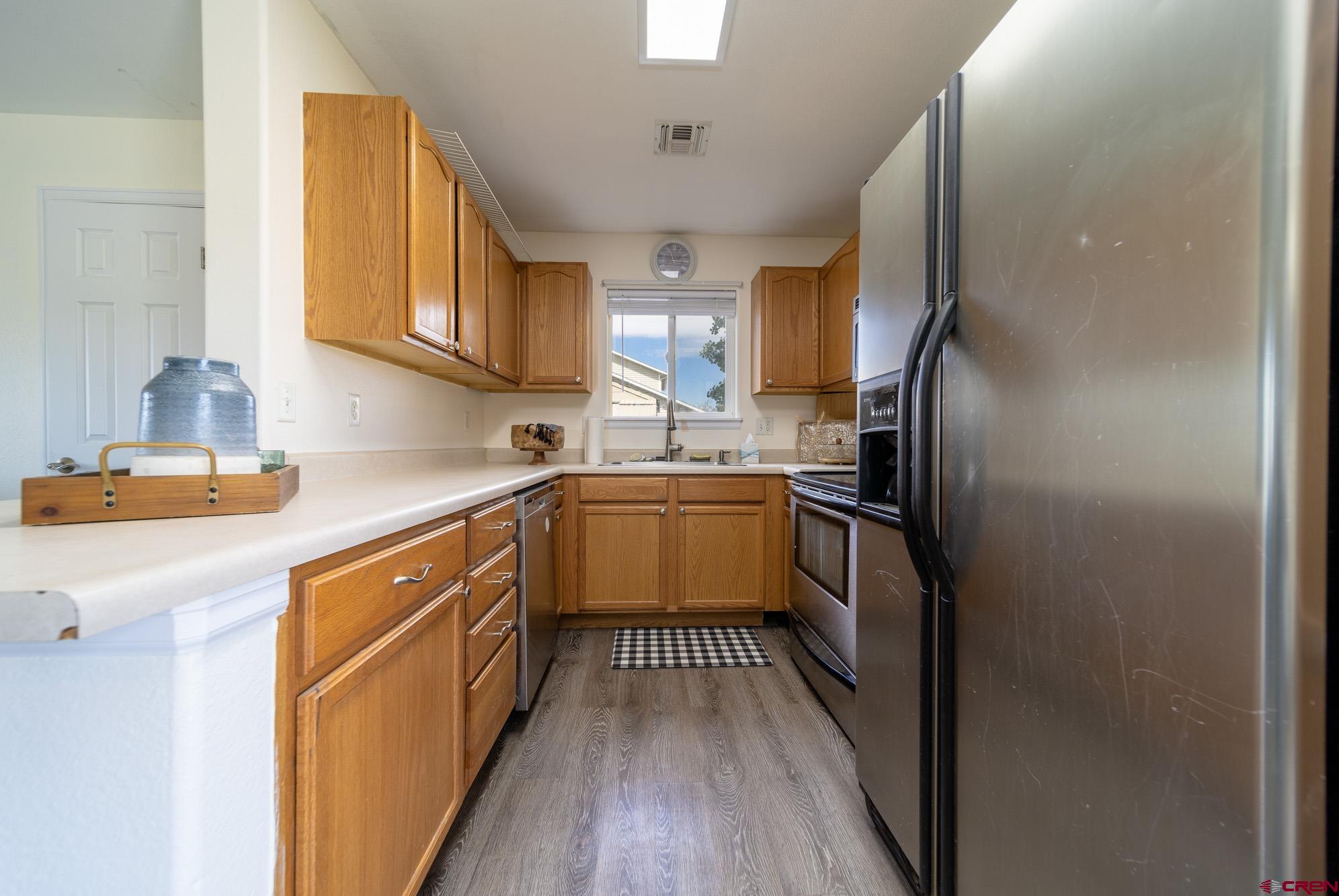 1531 Haystack Road Montrose, CO 81401 - Photo 11 of 34 a kitchen with a sink refrigerator and cabinets