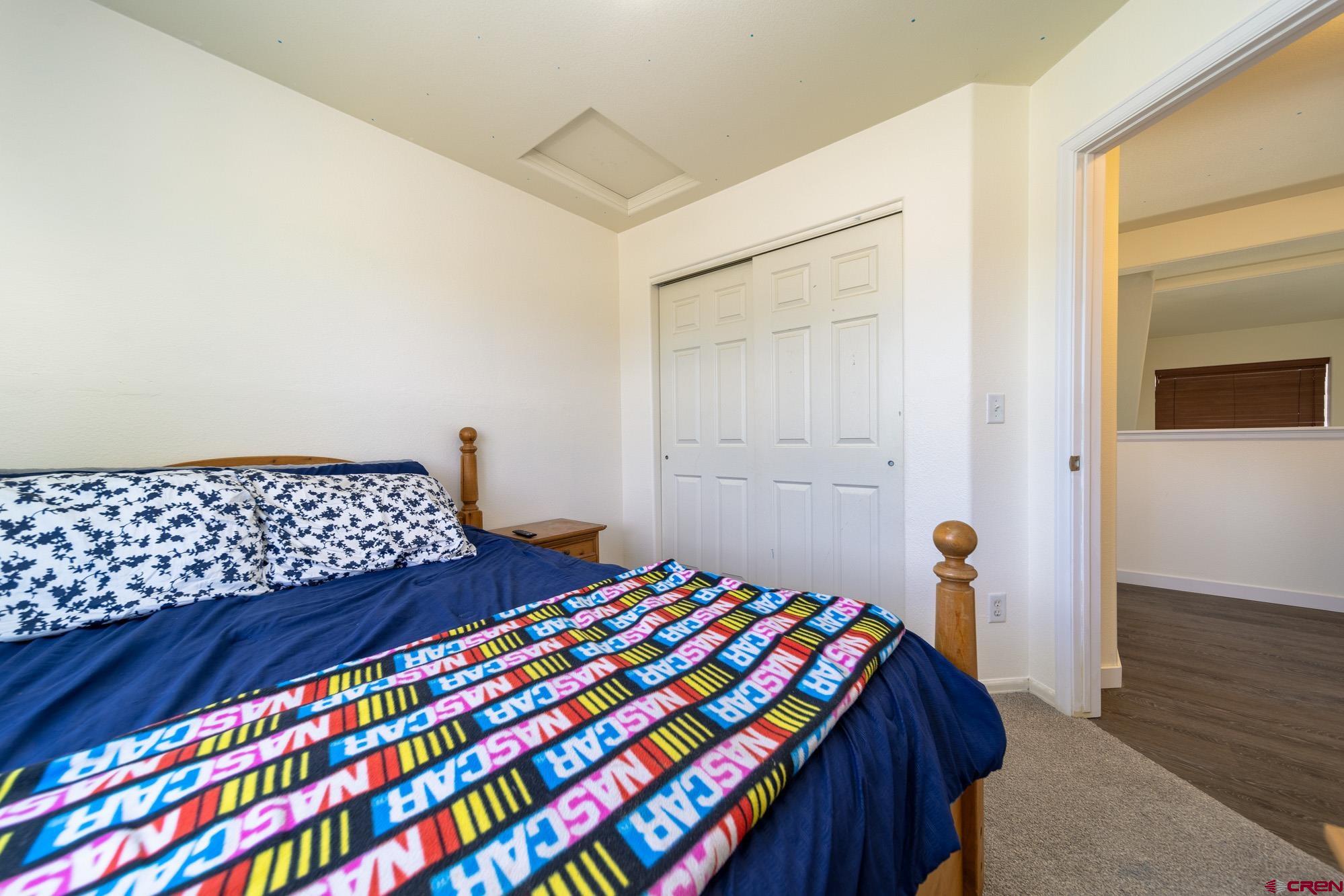 1531 Haystack Road Montrose, CO 81401 - Photo 20 of 34 a bedroom with a bed and wooden floor