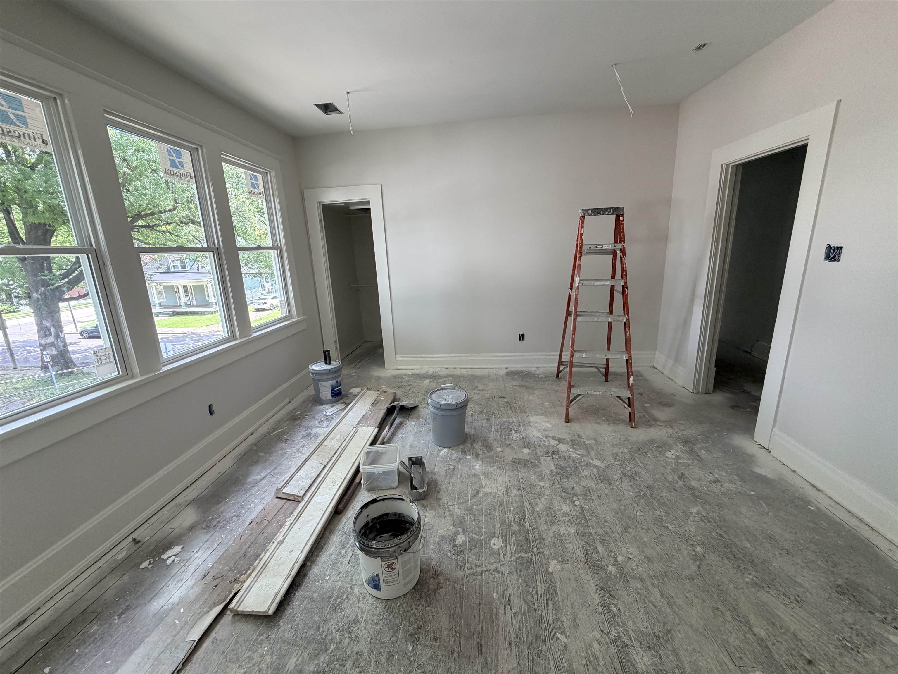 961 Meda Street Memphis, TN 38104 - Photo 17 of 27 Room featuring three large windows, white trim, and light-toned walls