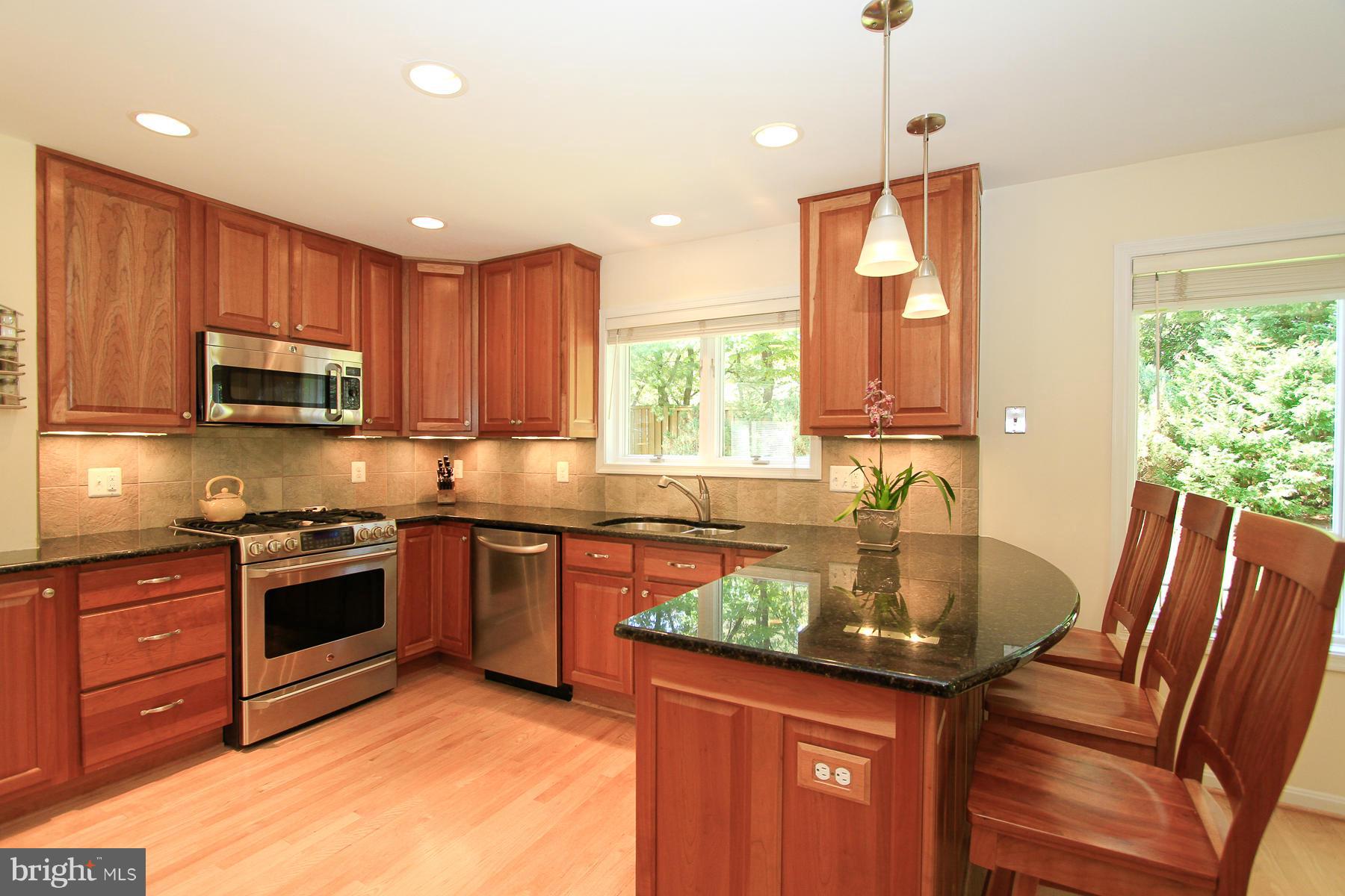 1304 Pavilion Club Way Reston, VA 20194 - Photo 8 of 30 a kitchen with stainless steel appliances granite countertop a sink a stove a microwave a refrigerator and cabinets