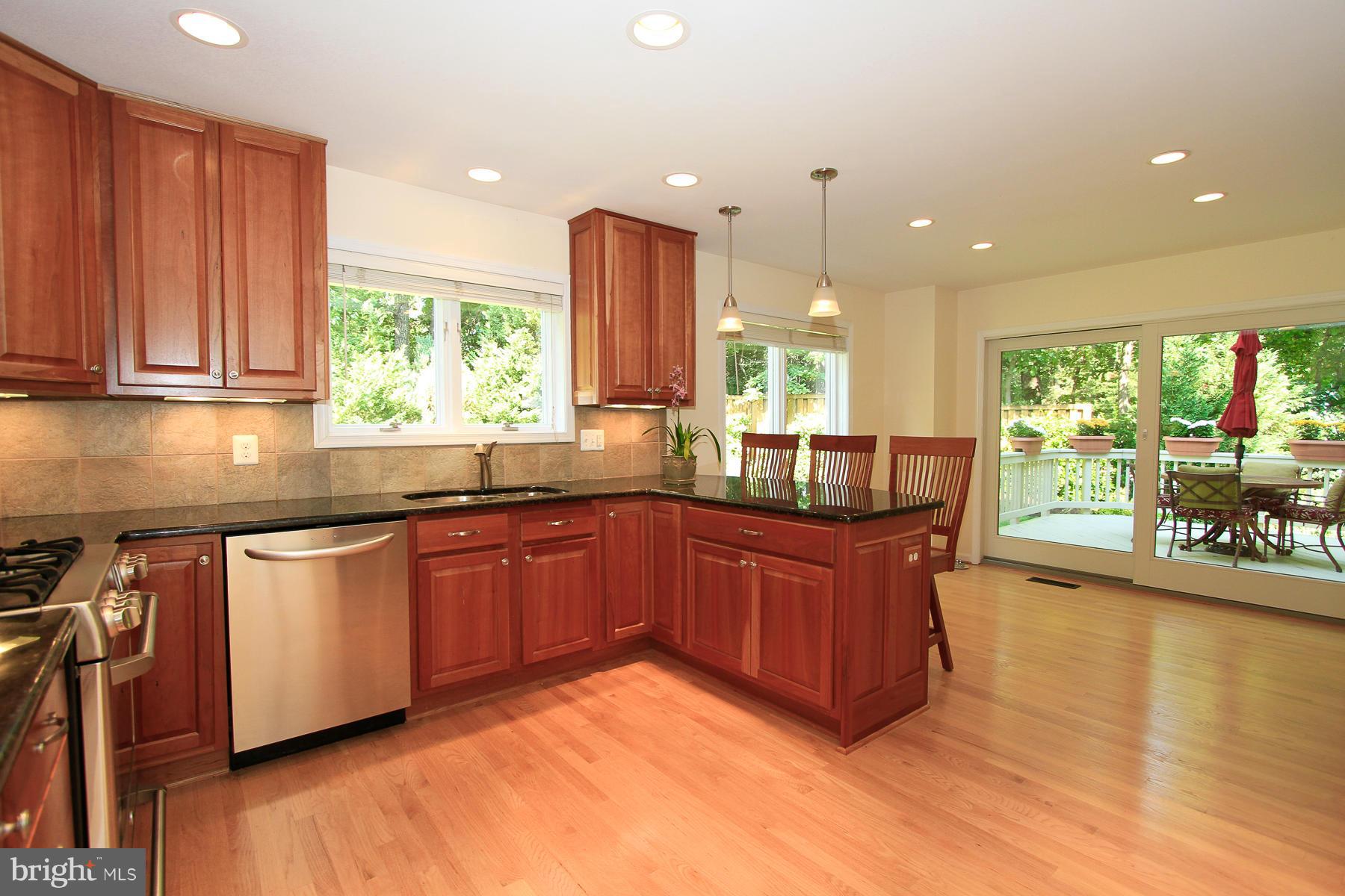 1304 Pavilion Club Way Reston, VA 20194 - Photo 9 of 30 a kitchen with stainless steel appliances granite countertop wooden cabinets a stove a sink and a large window
