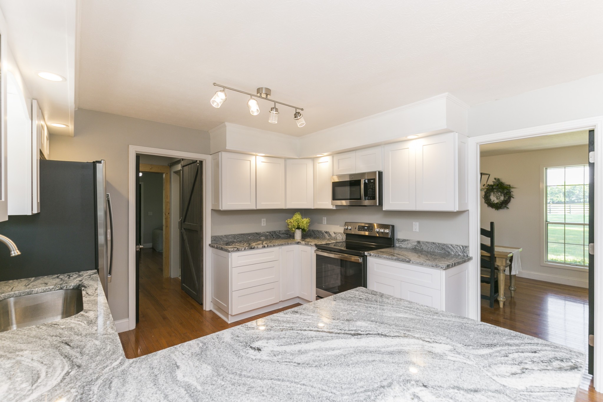 848 Philadelphia Road Lebanon, TN 37087 - Photo 7 of 50 a kitchen with stainless steel appliances kitchen island granite countertop a refrigerator oven a sink dishwasher and white cabinets with wooden floor