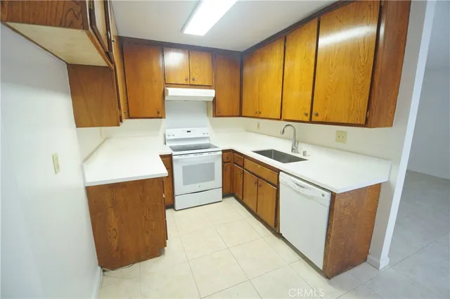 a kitchen with a sink a stove cabinets and a wooden floor