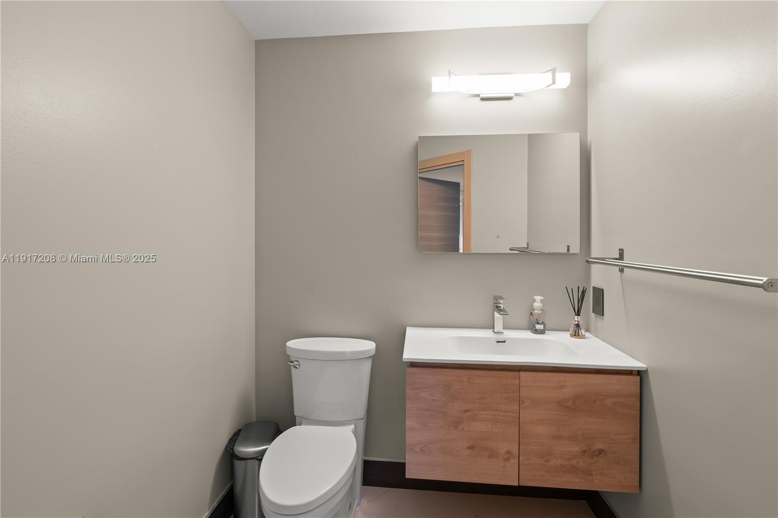 60 Southwest 13th Street, Unit 1400 Miami, FL 33130 - Photo 24 of 46 a bathroom with a sink a toilet and mirror