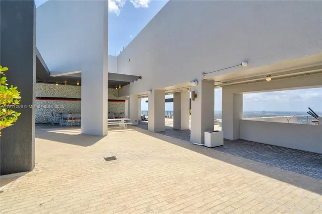 a view of roof deck with couches and potted plants