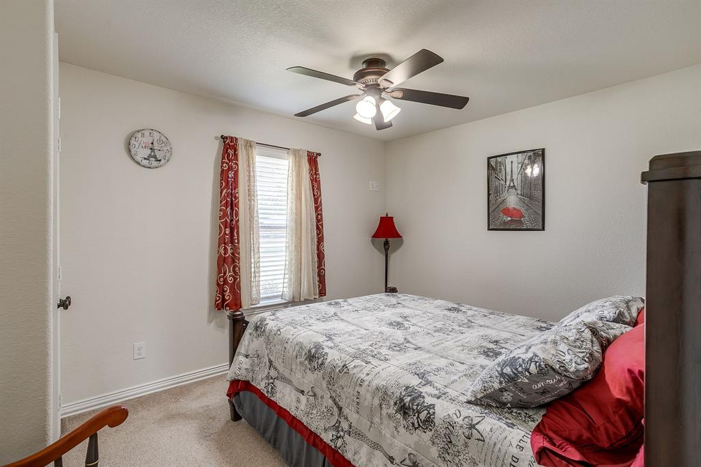 206 King George Way Ponder, TX 76259 - Photo 14 of 32 a bedroom with a bed and a chandelier