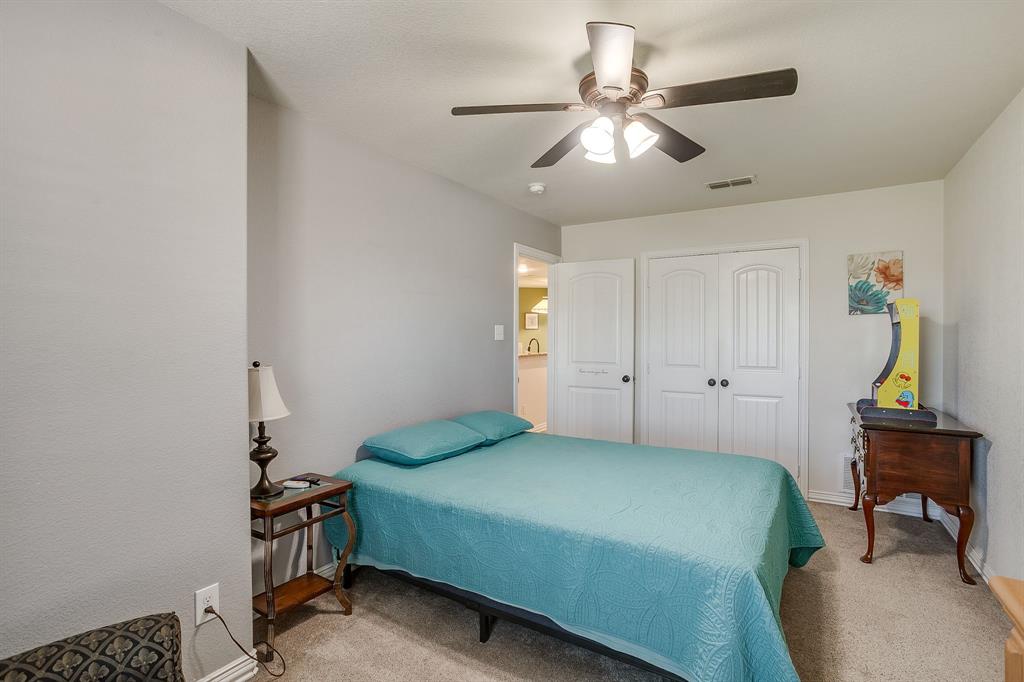 206 King George Way Ponder, TX 76259 - Photo 16 of 32 a bedroom with a bed and a chandelier