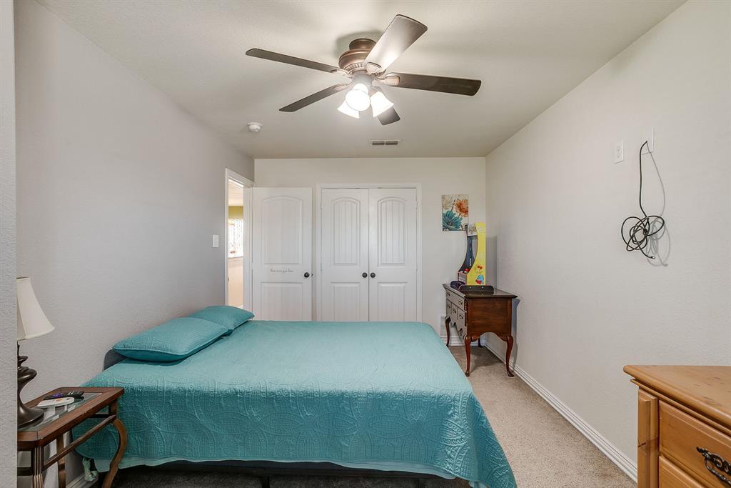206 King George Way Ponder, TX 76259 - Photo 17 of 32 a bedroom with a bed and a chandelier