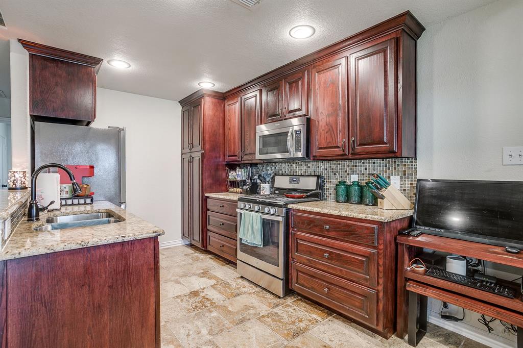 206 King George Way Ponder, TX 76259 - Photo 7 of 32 a kitchen with stainless steel appliances granite countertop wooden cabinets sink and stove top oven