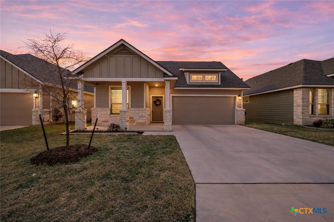 a front view of a house with a yard and garage