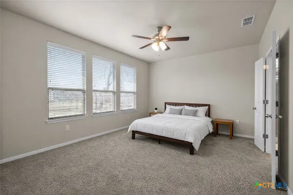 a spacious bedroom with a bed and a chandelier