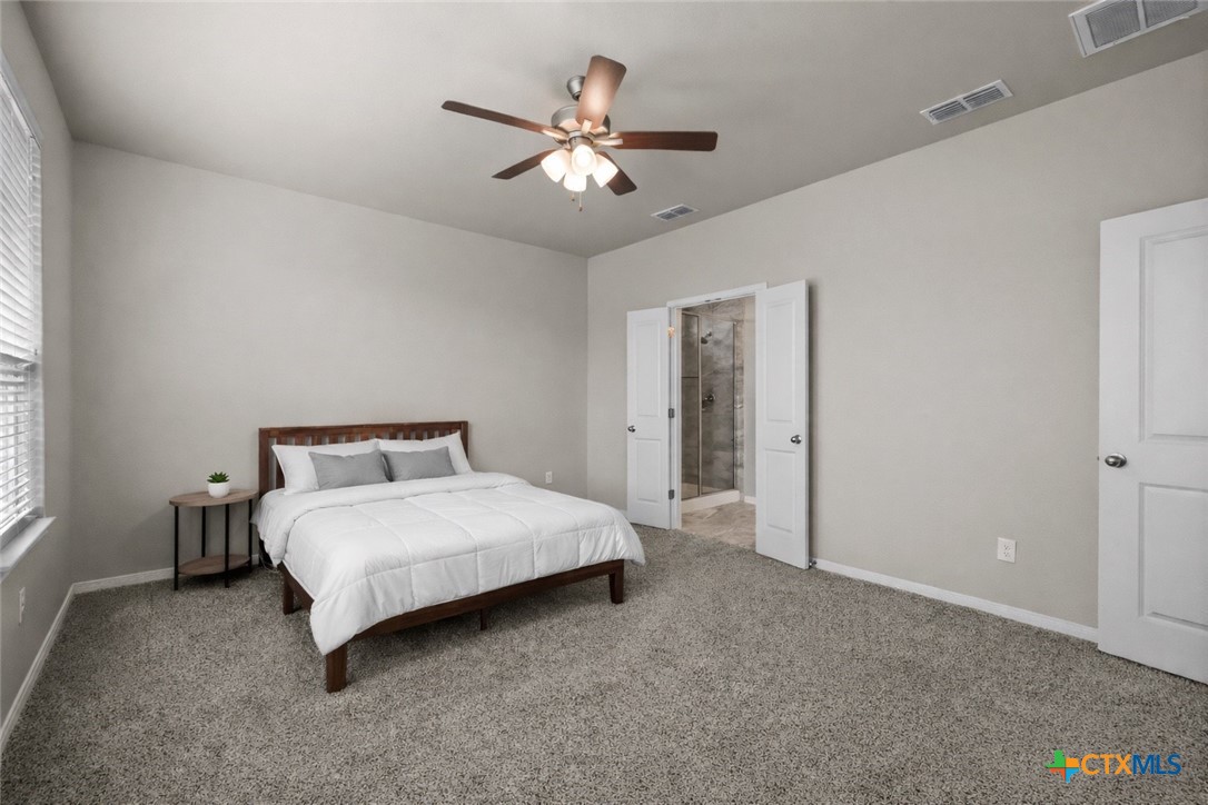 620 Ripplewood Drive Temple, TX 76502 - Photo 13 of 29 a spacious bedroom with a bed and a chandelier