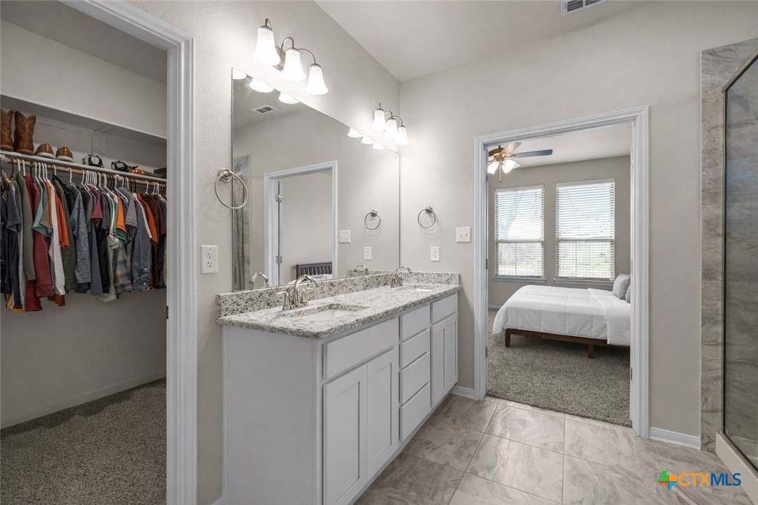 620 Ripplewood Drive Temple, TX 76502 - Photo 17 of 29 a en suite bathroom with a sink a large mirror and a shower