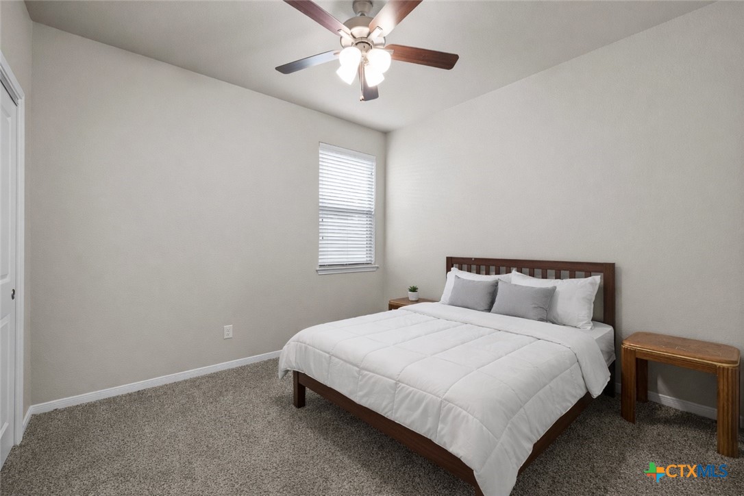620 Ripplewood Drive Temple, TX 76502 - Photo 20 of 29 a bedroom with a bed and a chandelier