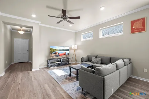 a kitchen with stainless steel appliances granite countertop a refrigerator a sink dishwasher a stove and white countertops with wooden floor