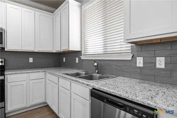 a kitchen with stainless steel appliances granite countertop a sink a stove a microwave and cabinets