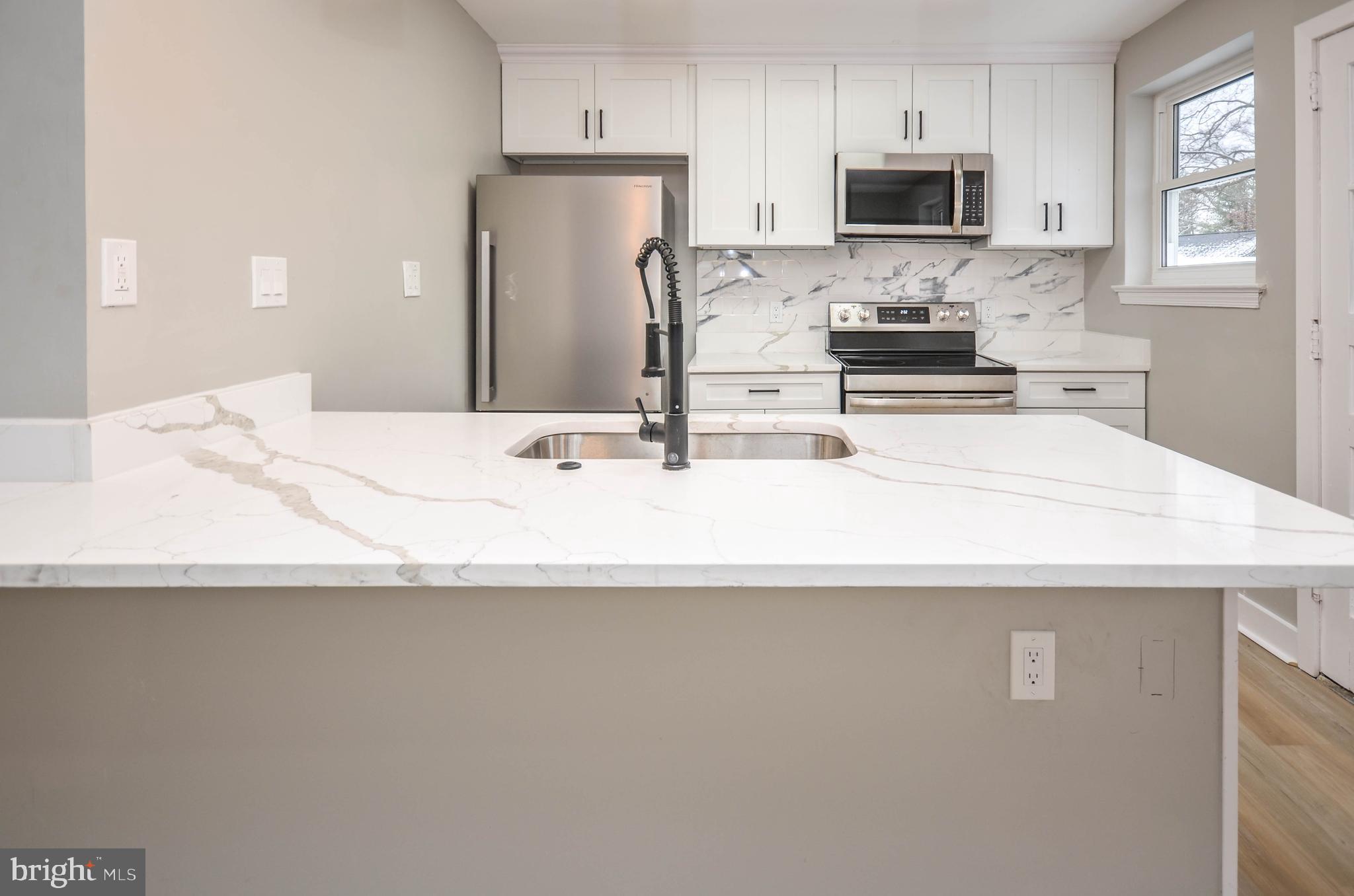 2110 Rolander Street Hyattsville, MD 20783 - Photo 11 of 33 a kitchen with stainless steel appliances a sink a stove top oven a counter space and cabinets