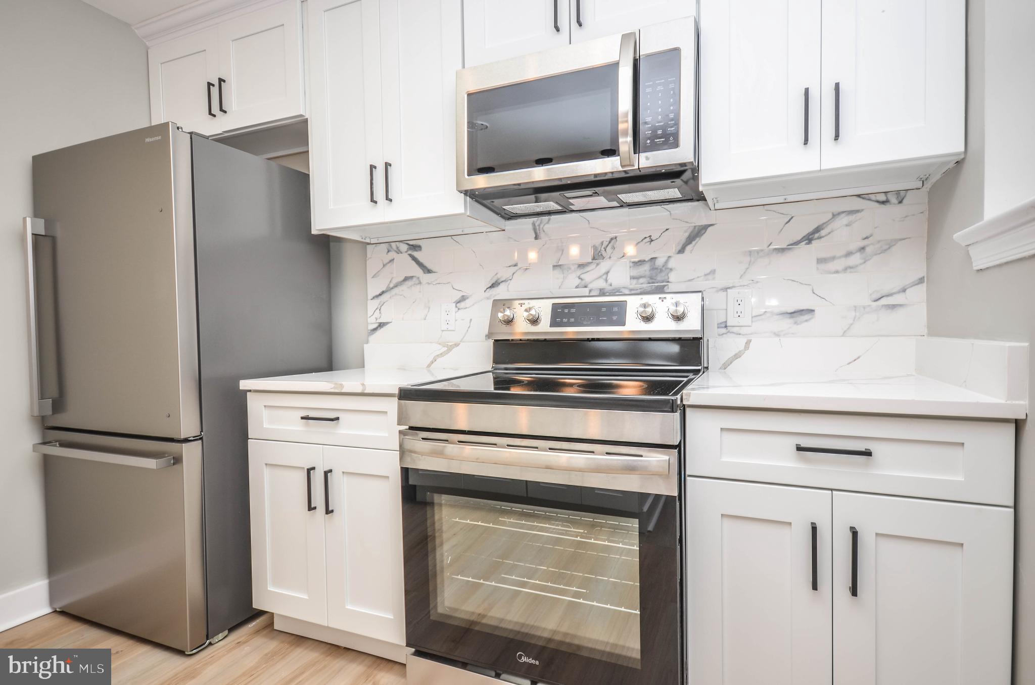 2110 Rolander Street Hyattsville, MD 20783 - Photo 12 of 33 a kitchen with stainless steel appliances white cabinets and a refrigerator