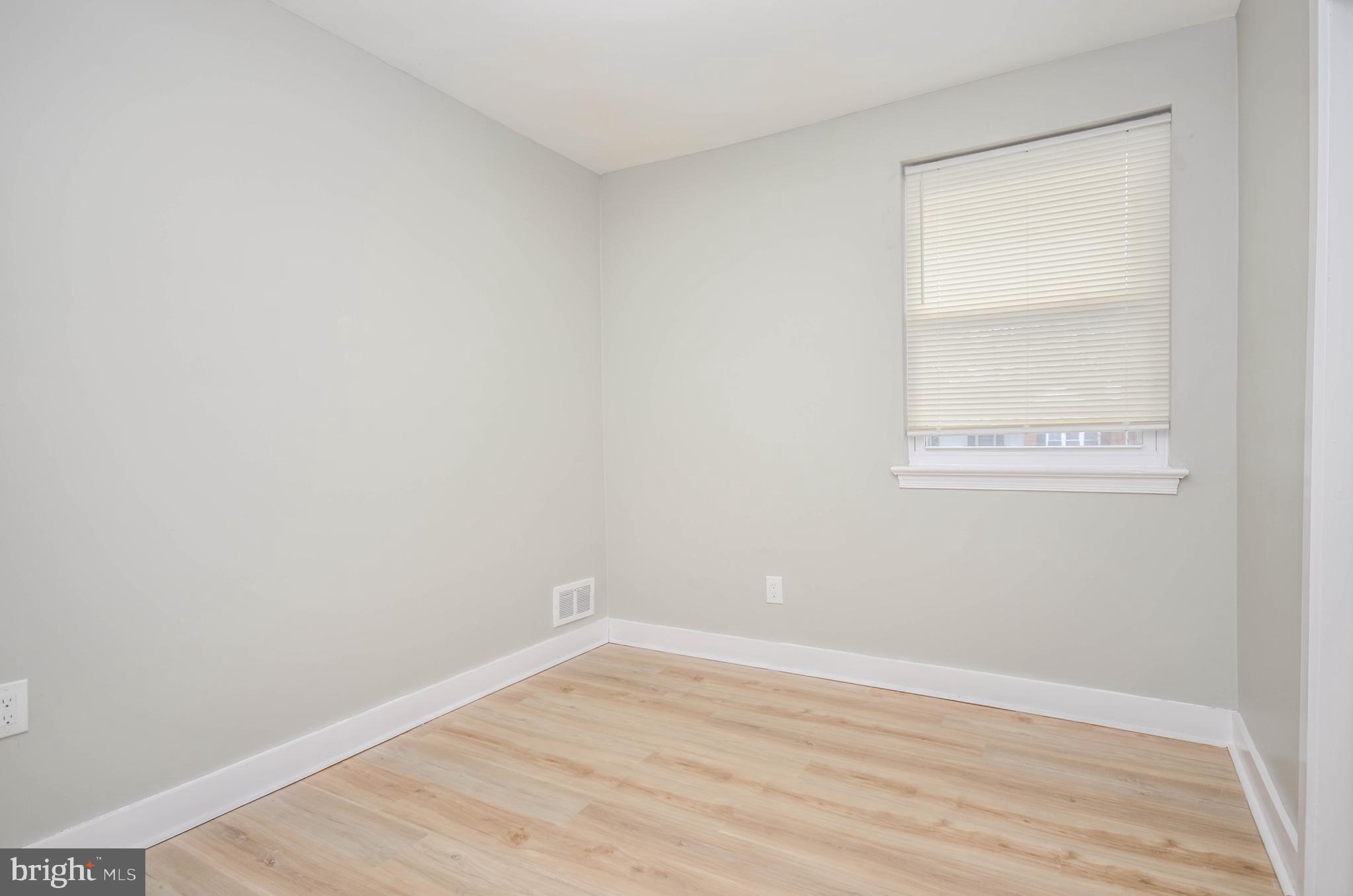 2110 Rolander Street Hyattsville, MD 20783 - Photo 14 of 33 a view of an empty room with wooden floor and a window