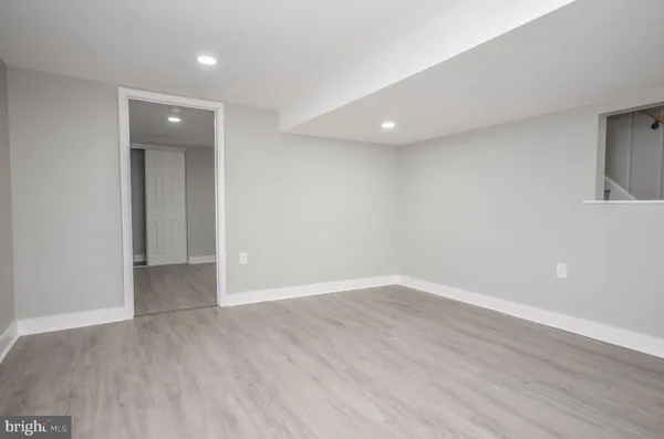 a view of an empty room with wooden floor and closet