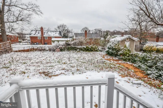 a view of a dry yard with wooden fence