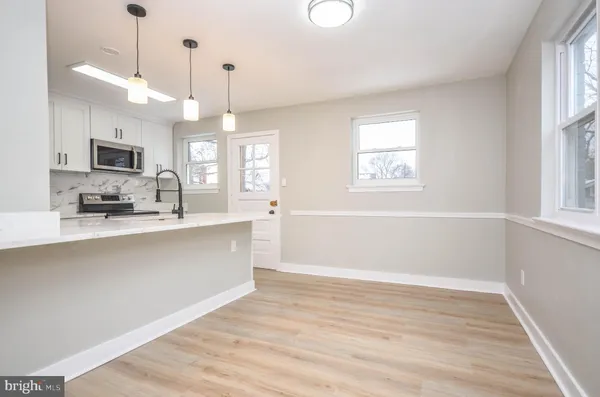 a view of a kitchen with a sink wooden floor and a window