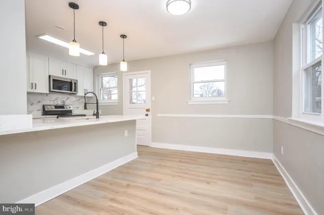 a view of a kitchen with a sink wooden floor and a window