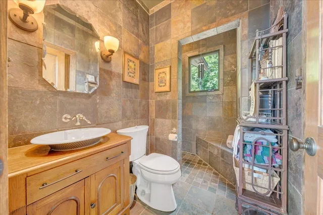 a bathroom with a granite countertop sink and a bathtub