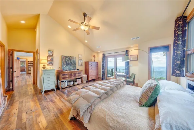 a bed sitting in a spacious bedroom next to a large window