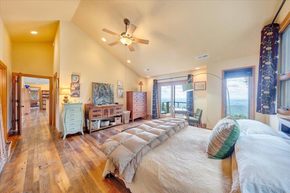 490 Lookout Ridge Lane Copper Hill, VA 24079 - Photo 31 of 69 a spacious bedroom with a large bed a chandelier and windows