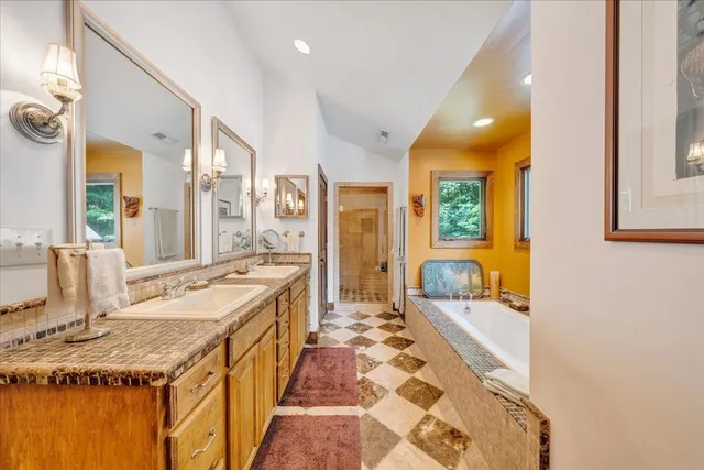 a bathroom with a granite countertop sink a mirror a lamp