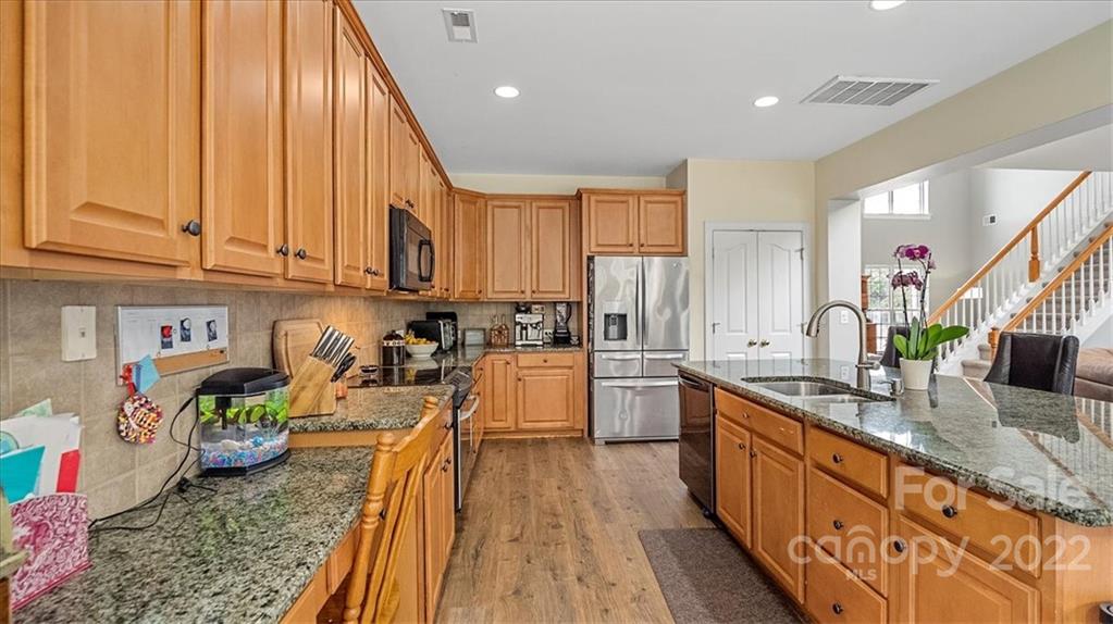 2001 Dataw Lane Indian Trail, NC 28079 - Photo 11 of 38 a kitchen with stainless steel appliances granite countertop a sink a stove and a wooden floors