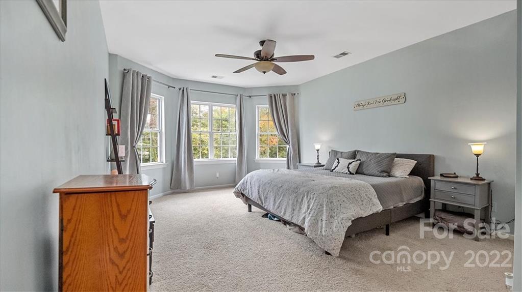 2001 Dataw Lane Indian Trail, NC 28079 - Photo 19 of 38 a spacious bedroom with a bed and a chandelier
