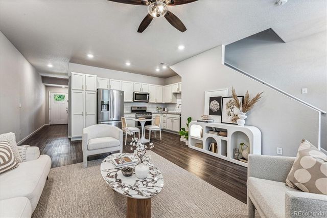 a living room with furniture and kitchen view