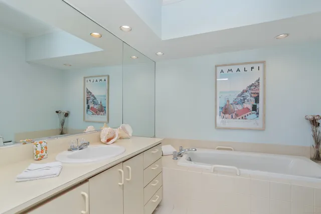 a bathroom with a tub sink and mirror