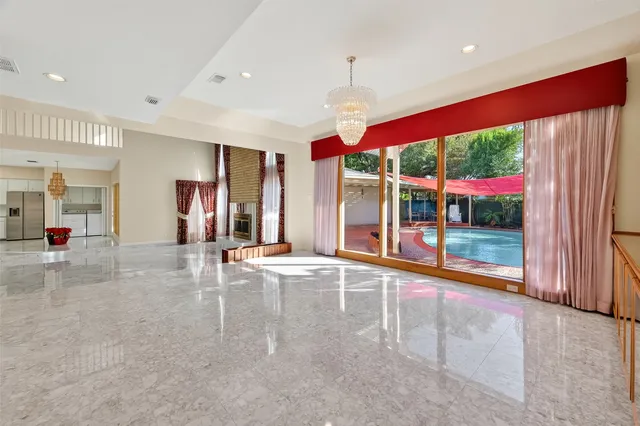 a view of a big room with windows and chandelier