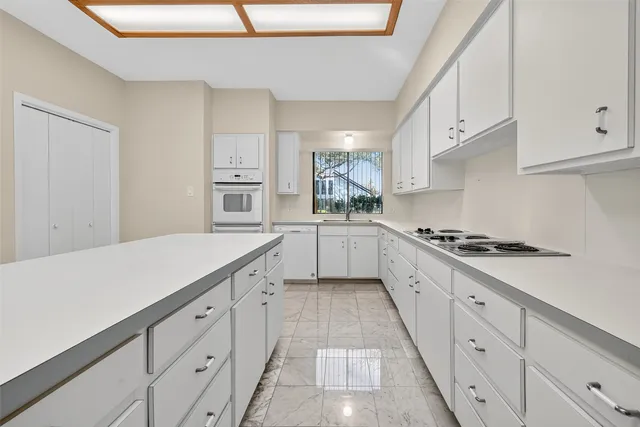 a kitchen with granite countertop white cabinets and white appliances